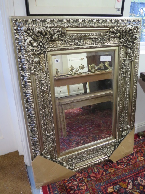 An ornate silver coloured mirror - 122cm high x 95cm wide