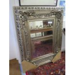 An ornate silver coloured mirror - 122cm high x 95cm wide