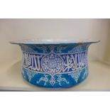 A large Islamic style enameled terracotta bowl, glazed in turquoise and blue with white interior,