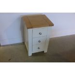 A painted three drawer bedside chest with an oak effect top, 71cm tall x 45cm x 40cm