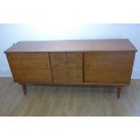 An Alfred Cox teak sideboard with three central drawers and two cupboard doors, 77cm tall x 171cm