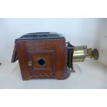 A Victorian mahogany and brass projector with four wick burner, missing chimney, 28cm tall x 45cm