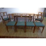 An Alfred Cox teak extending dining table and six chairs, including two carvers, table 74cm tall x