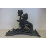 An oriental bronze dragon stand in a scroll base, 25cm tall x 33cm x 15cm - signed to base with a