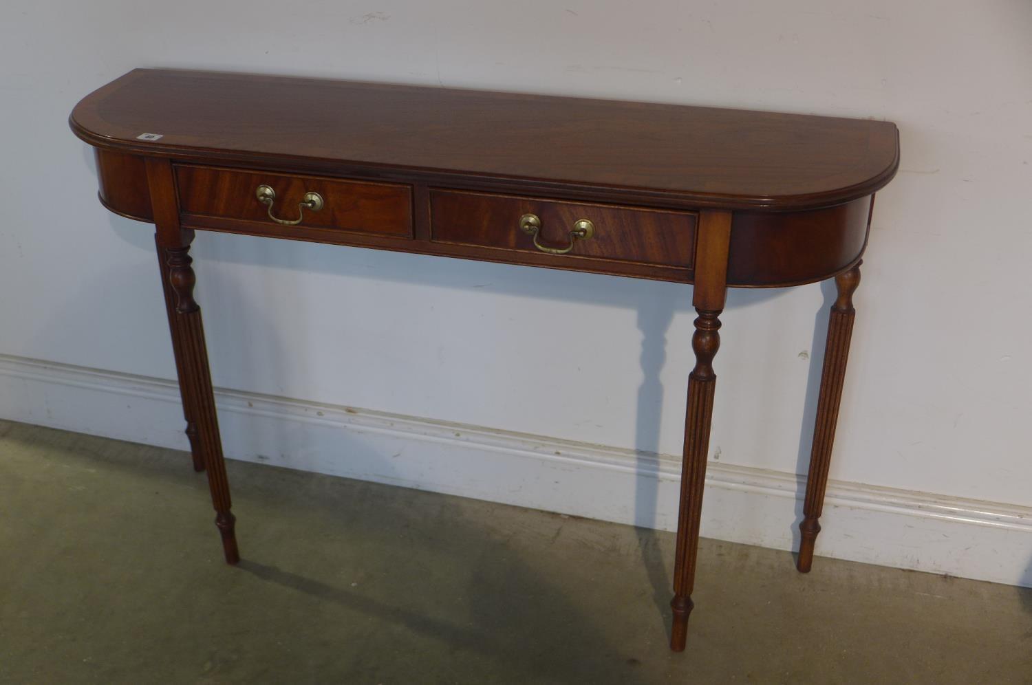 A mahogany two drawer D-end side table cross banded in yew wood, standing on tapered turned and