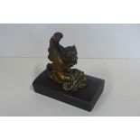 A small cast bronze winged mythical creature figurine with the head of a lion and body of female