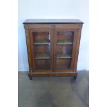 A late Victorian walnut, strung, inlaid ormulu mounted pier cabinet of two glazed doors on turned