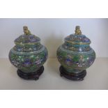 A pair of good quality cloisonne Chinese lidded vases on carved wooden stands, 19cm tall, 13cm wide,