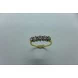 A hallmarked 18ct yellow gold five stone diamond ring, with five graduating stones claw set in rex