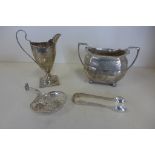 A silver cream jug, a silver sugar bowl, a pair of silver nips and a white metal sifter, total