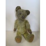 A vintage mohair teddy bear with boot button eyes, 27cm tall, general wear consistent with age,