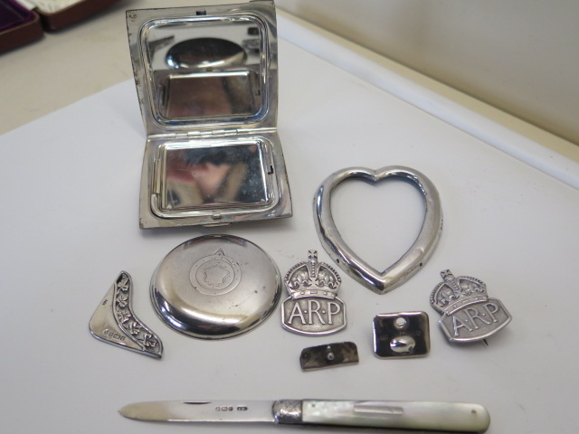 A silver compact and silver bladed fruit knife, two silver ARP badges and odd pieces of silver,