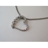 An 18ct white gold diamond set heart pendant on a 9ct white gold chain, 27cm long, total weight