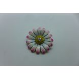 A un-hallmarked gold and enamel flower brooch with a central diamond, approx 3mm diameter, brooch is