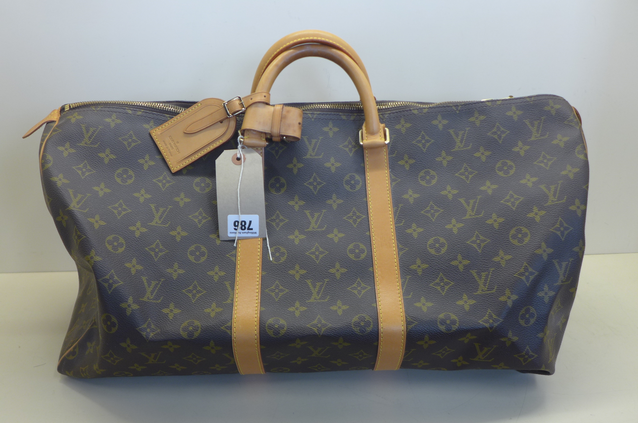 A Louis Vuitton monogram keepall 50 - 56x26x28cm, with padlock and keys, No 303, with luggage label,