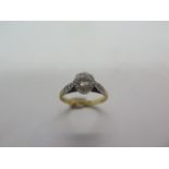 An 18ct yellow gold and platinum solitaire diamond ring set with four small diamonds to the