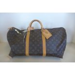 A Louis Vuitton Monogram keepall 55 - with strap 51x23x26cm - with luggage label, lock and keys , No