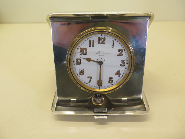 A silver travel watch/clock case with an associated Asprey 8 day watch, not working, glass