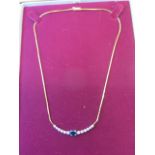 A hallmarked 18ct gold diamond and sapphire necklace, 1cm long, the centre sapphire approx 6x5x3mm -