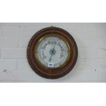 An oak carved aneroid barometer - 34cm diameter