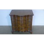 An 18th/19th century walnut serpentine fronted bachelor chest with a slide above four leather banded