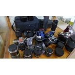 A collection of assorted camera equipment including four 35mm SLR cameras , assorted lenses and a