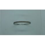 A white 9ct gold diamond hinged bangle set with two rows of small white round cut diamonds, diameter
