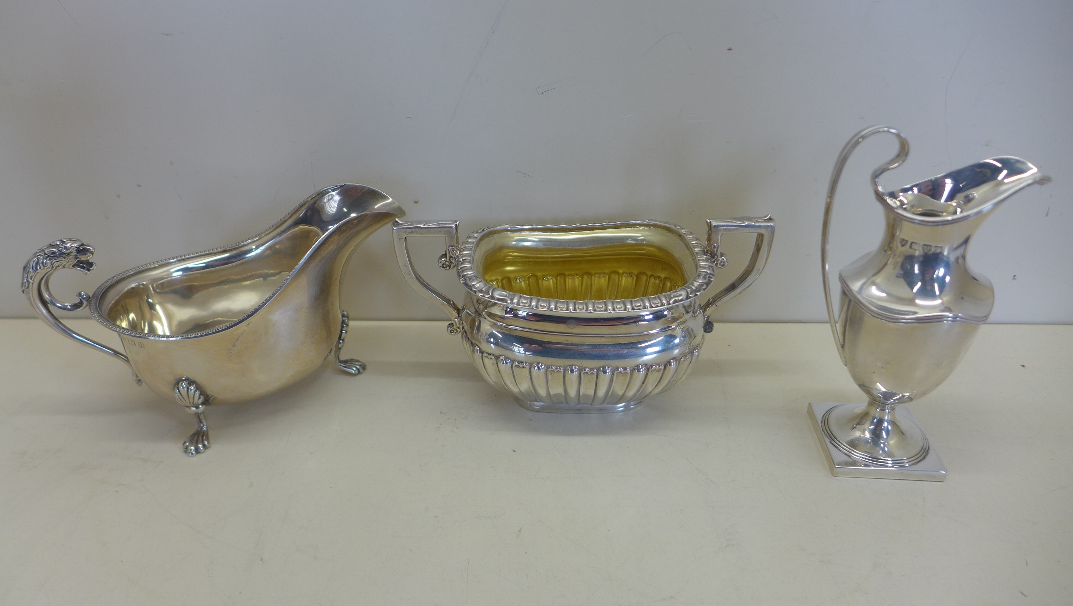 A silver twin handled sugar bowl, Birmingham 1902 - a silver cream jug Chester 1906 - and a silver