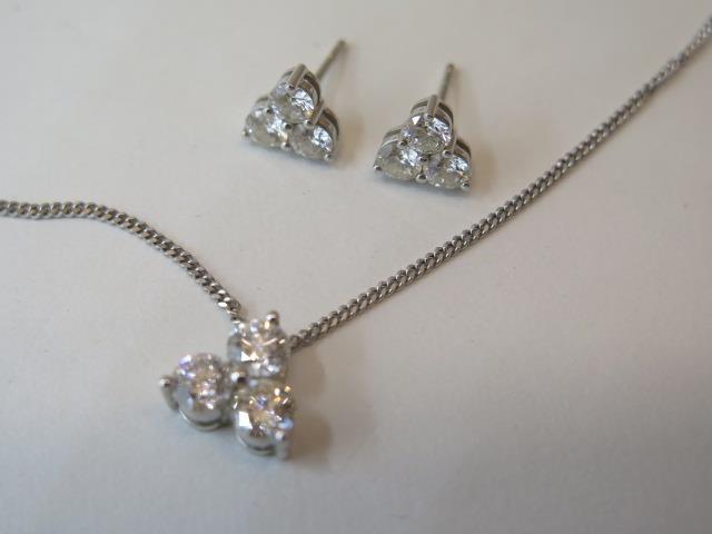 An 18ct white gold three stone diamond pendant on chain, total diamonds approx 1ct with matching