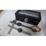 Four unused Quartz watches in a display or storage box