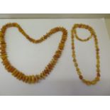 Two strings of natural polished amber beads, deep honey and egg yolk colours, larger string 74cm