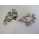 Two silver charm bracelets with various silver and white metal charms - approx 70 grams