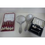 A boxed set of silver teaspoons, a silver spoon and pusher and a silver backed brush and mirror -