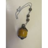 An Asian white metal and amber style necklace, the m large amber or resin bead measures 5x4.5cm,