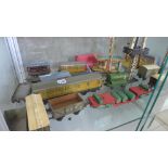 A collection of tinplate O gauge rolling stock and one clockwork loco, all play worn and buildings