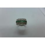 A hallmarked 18ct white gold three row emerald and diamond ring, size O, approx 7.4 grams, generally