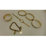 Four rolled gold bangles, a rolled gold bracelet with two hallmarked 9ct charms, and a rolled gold