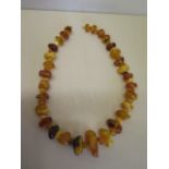 A good string og un-cut polished amber beads, varying colours and clarity, 71cm length, total weight
