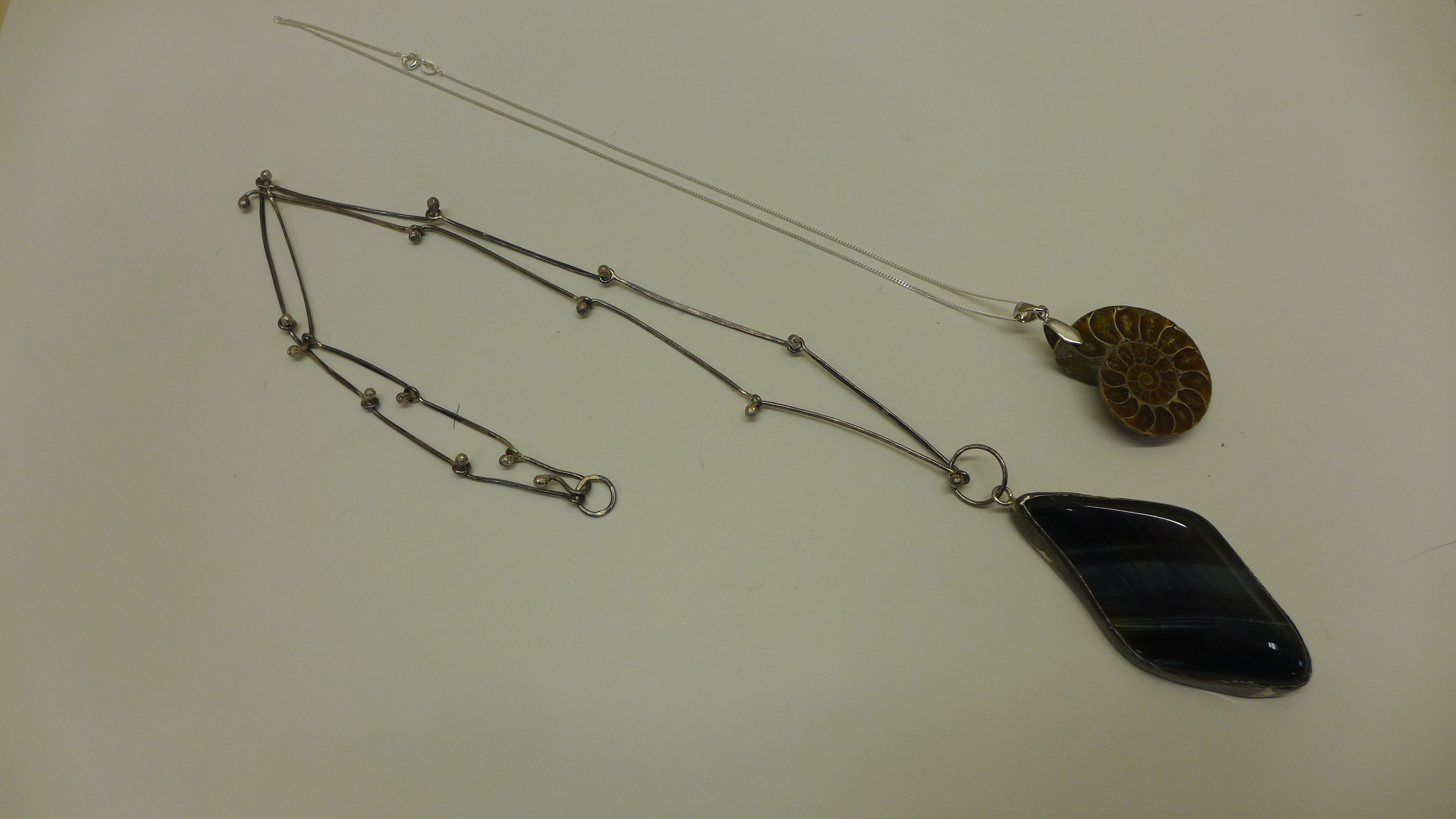 An amonite pendant on silver chain and a silver mounted labrodite pendant on silver chain