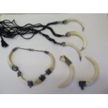 A wild boar tusk and white metal mount necklet, three boar tusk and white metal necklaces and two