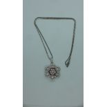 An 18ct white gold diamond and ruby pendant, marked 750 on a 9ct white gold chain - chain length