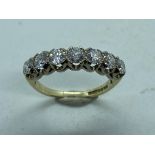An impressive 9ct diamond ring set with seven stones, round brilliant cut, totaling just under 1ct
