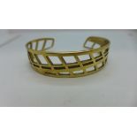 A hallmarked 9ct yellow gold open work bangle 6cm wide x 1.5cm in height, approx 21.6 grams -