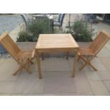 A new boxed teak bistro table 70cm x 70cm and two folding dining chairs.