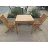 A new boxed teak bistro table 70cm x 70cm and two folding dining chairs.