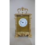 An ornate gilt repainted carriage clock 19cm tall, running with key, striking on a gong with repeat