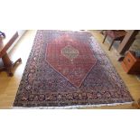A hand knotted woollen rug 340cm x 237cm - some general usage wear but reasonably good condition
