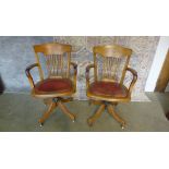 A pair of oak swivel desk chairs with leather padded seat by Simpoles of Manchester. 92cm tall, 59cm