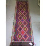 A hand knotted woolen runner 252 x 75cm in good condition