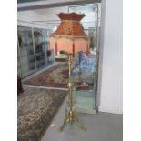 A brass orangery conservatory standard oil lamp now converted to electric with a fringed shade,